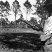 A worker holds a hack used for cutting pines for turpentine