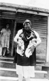 African American midwife holding twins.