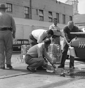 City police officers pouring 100 gallons of moonshine into the sewer in Tallahassee.