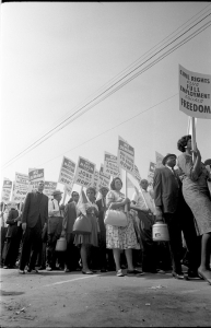 Demonstrators marching in the street holding signs with messages supporting equal employment and civil rights during the March on Washington.