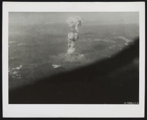 Aerial photograph of the first atomic bombing of Hiroshima, Japan, showing the mushroom cloud beginning to rise.