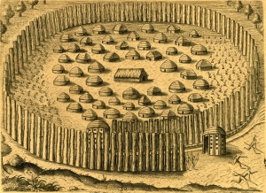 Engraving of an Indigenous town with dome-shaped buildings surrounded by wooden pillars that are arranged in an oval shape.