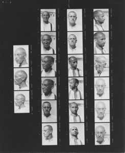 Contact sheet or vertical strips of negatives of prisoner identification photographs from Dachau concentration camp showing men photographed from the front and in profile.