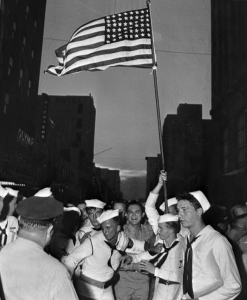 U.S. Navy sailors in uniform celebrating V-J Day in a street in Miami.